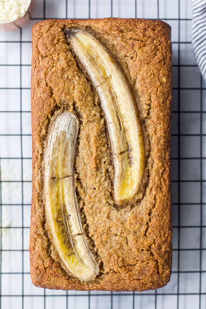 The Best Almond Flour Banana Bread Ever 一个未切片的旧香蕉面包,上面有两个香蕉