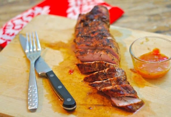 The Best 4th of July Grilling Recipes 用刀叉在砧板上放芒果酸辣酱猪里脊片