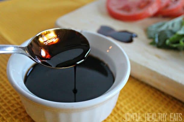 Cauliflower Alfredo Sauce Balsamic Reduction in a White Container Beside a Wooden Cutting Board