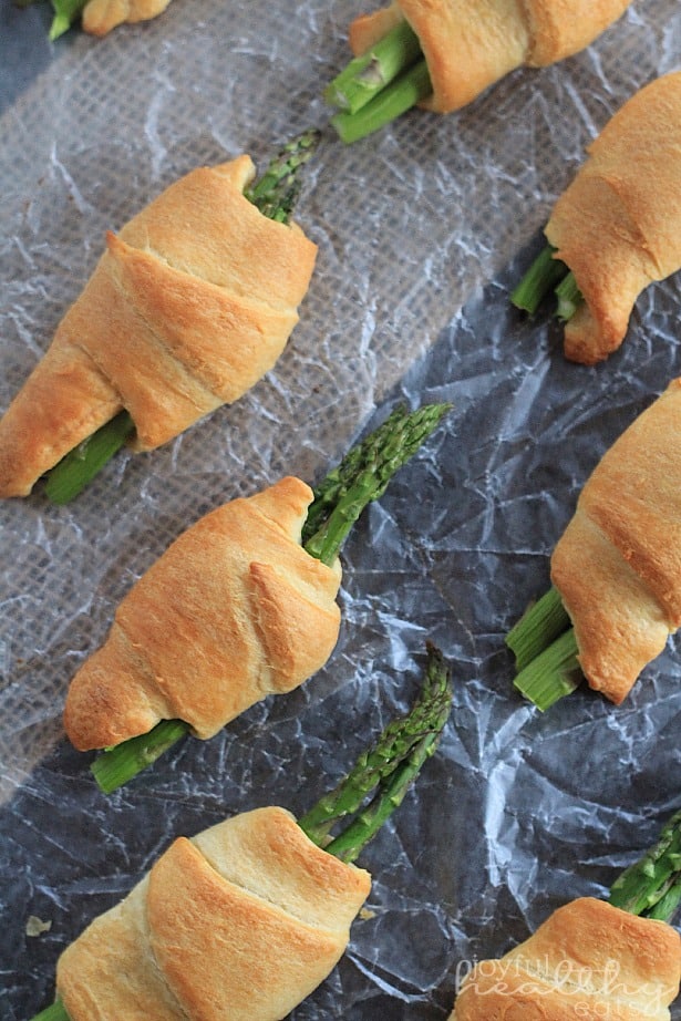 Asparagus Rollups with a Balsamic Reduction Drizzle 芦笋卷排列在一张蜡纸上