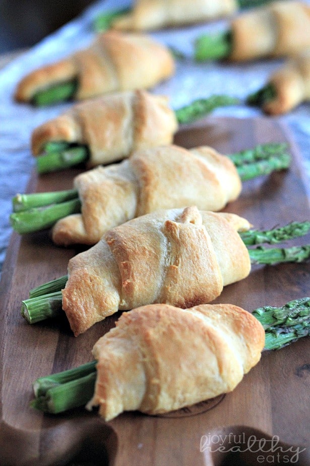 Asparagus Rollups with a Balsamic Reduction Drizzle 芦笋卷在木板上排成一行