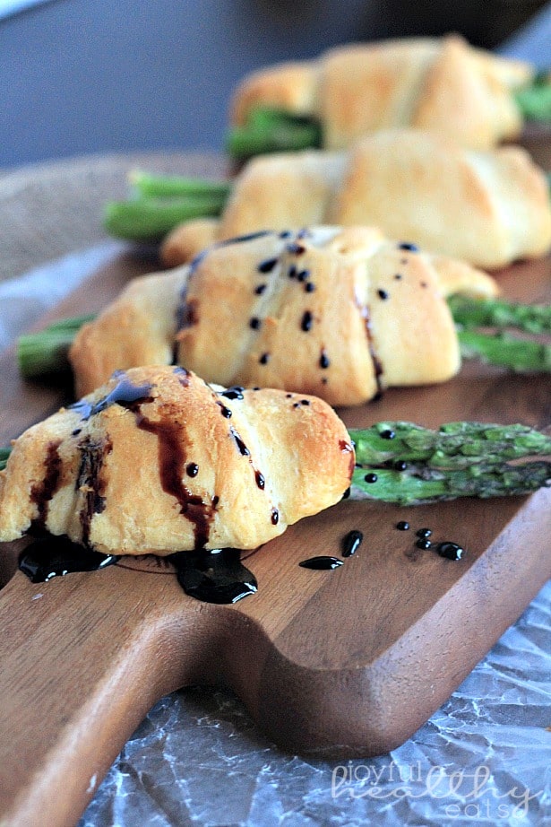Asparagus Rollups with a Balsamic Reduction Drizzle 木板上的四个芦笋卷