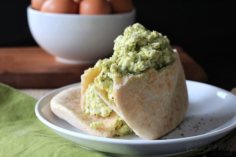 Avocado Egg Salad 在一碗硬煮鸡蛋旁边的板材的鳄梨蛋沙拉