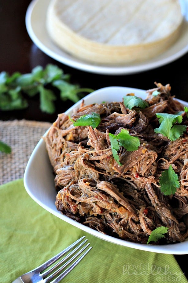 Crock Pot Chipotle Beef Barbacoa #crockpot #beef #shredded #slowcooker #texmex 碎牛肉芭芭卡在一个碗里,旁边是玉米饼壳
