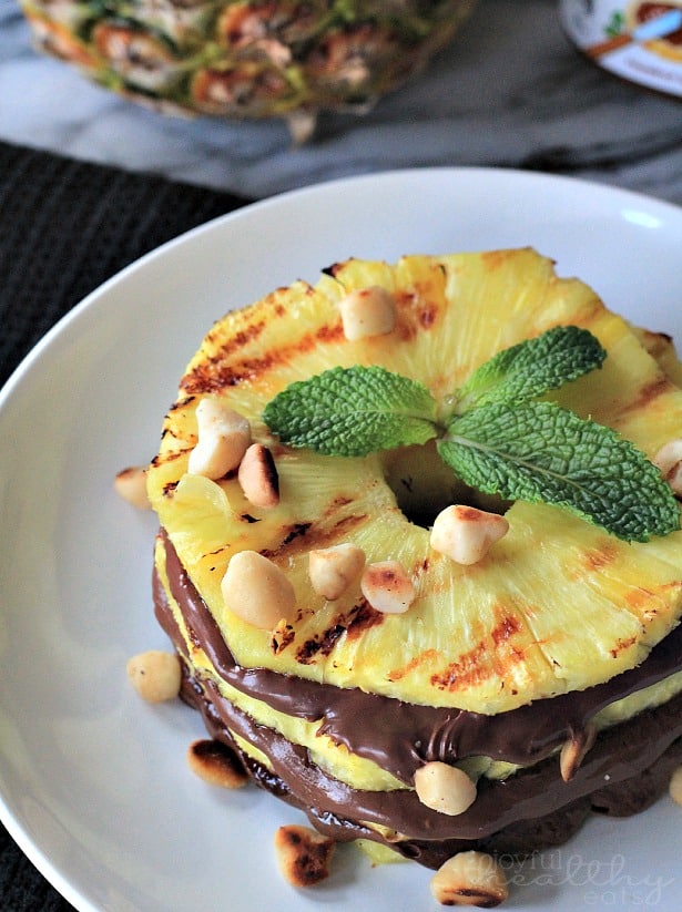 Grilled Pineapple with Nutella & Macadamia Nuts #dessert #healthy #grilled #pineapple #nutella 顶部视图烤菠萝环与Nutella和澳洲坚果在盘子上
