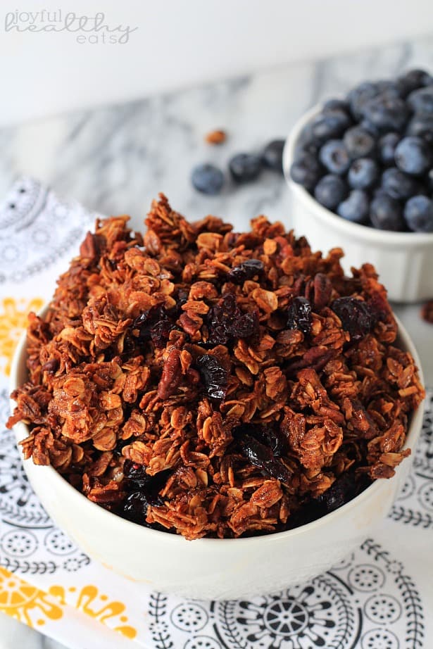Coconut Blueberry Pecan Granola #healthybreakfast #granola #blueberry #coconut #pecan 俯瞰一碗椰子蓝莓核桃格兰诺拉麦片旁边的新鲜蓝莓模子