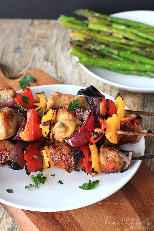 Chicken, Sausage, Pepper & Onion Kabobs 一堆鸡肉、香肠、胡椒和洋葱串放在盘子里