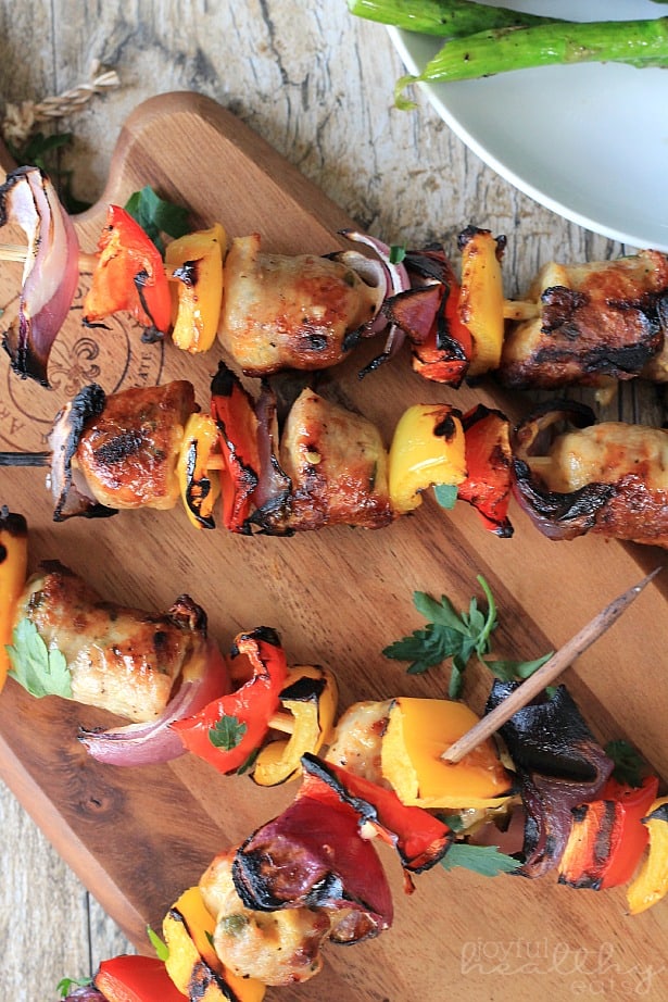 Grilled Chicken, Sausage, Pepper & Onion Kabobs 在砧板上的烤鸡,香肠,胡椒和洋葱串的俯视图