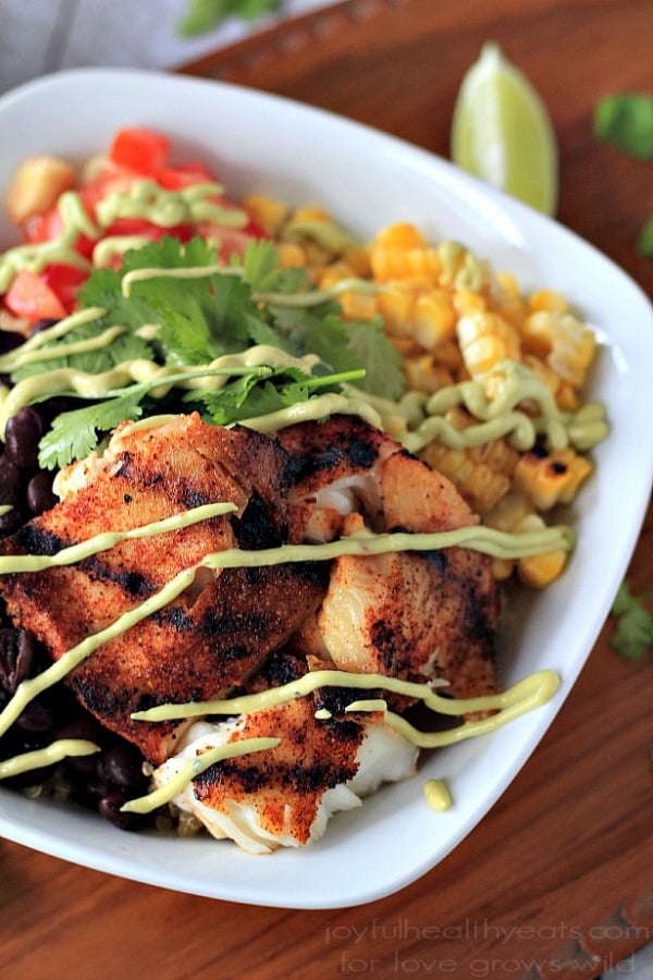 Grilled Tilapia Bowls with Chipotle Avocado Crema 烤罗非鱼在一个白色碗与蔬菜和牛油果奶油细雨