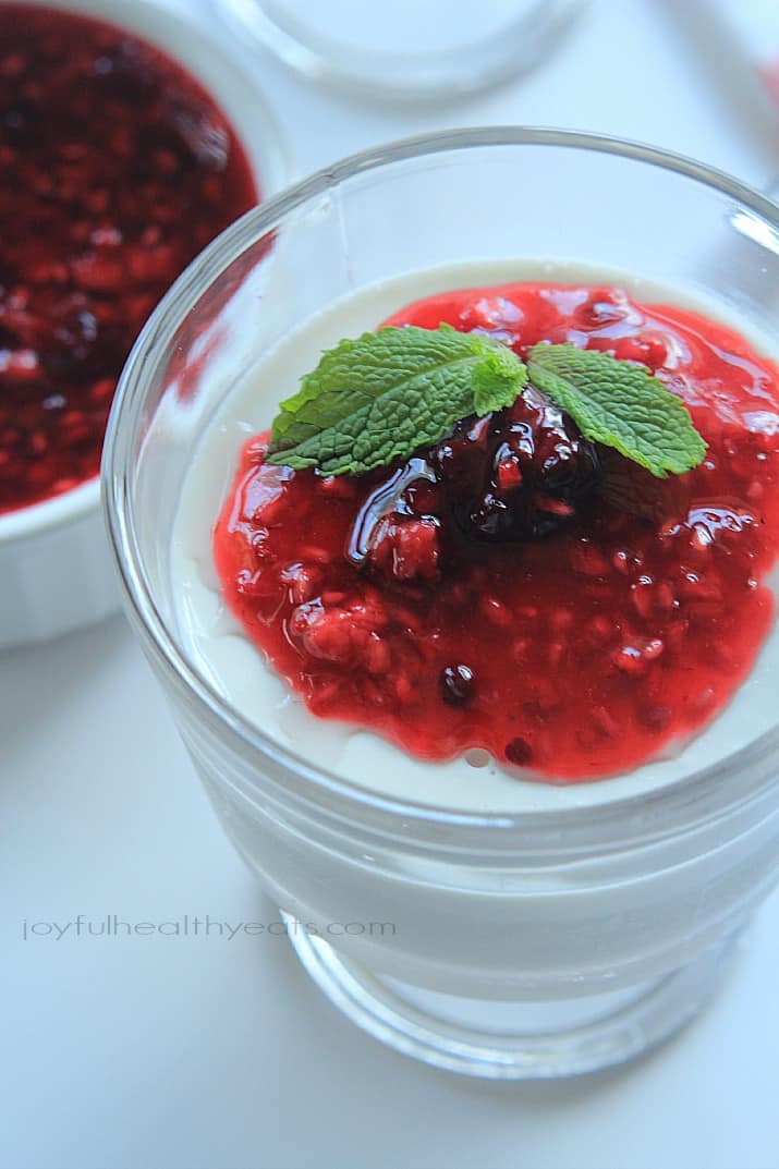 Creamy custard-like Coconut Panna Cotta topped with a tart Raspberry Blackberry Compote, it's an incredible dessert that you won't feel guilty eating! | joyfulhealthyeats.com #paleo #glutenfree 特写椰子意式奶冻淋上覆盆子黑莓果盘,放在甜点杯中