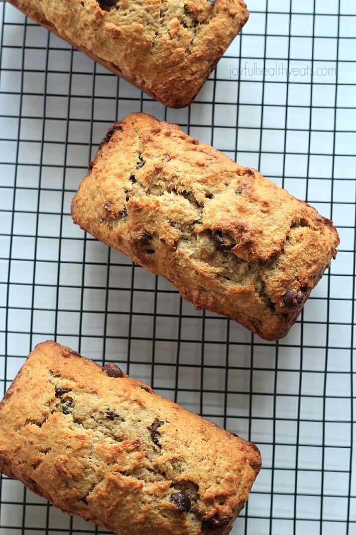 Fully loaded and fully delicious Coconut Pecan Chocolate Chip Banana Bread | m.albarakaa.com 三块椰子核桃巧克力片香蕉面包在冷却架上的俯视图