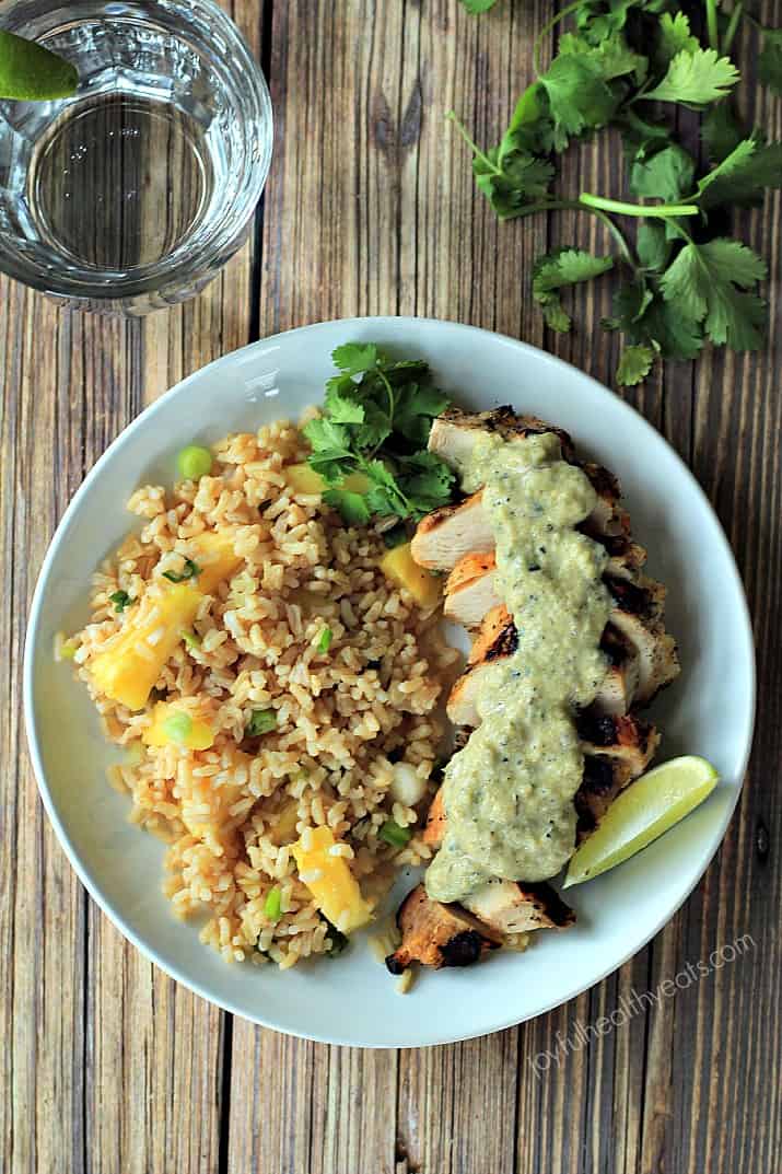 30 minute recipe that will fool anyone! Grilled Chicken Breast with Tomatillo Roasted Poblano Cream Sauce made with fresh ingredients and greek yogurt | m.albarakaa.com #glutenfree 俯视图的烤鸡配番茄沙司和菠萝米饭在盘子里