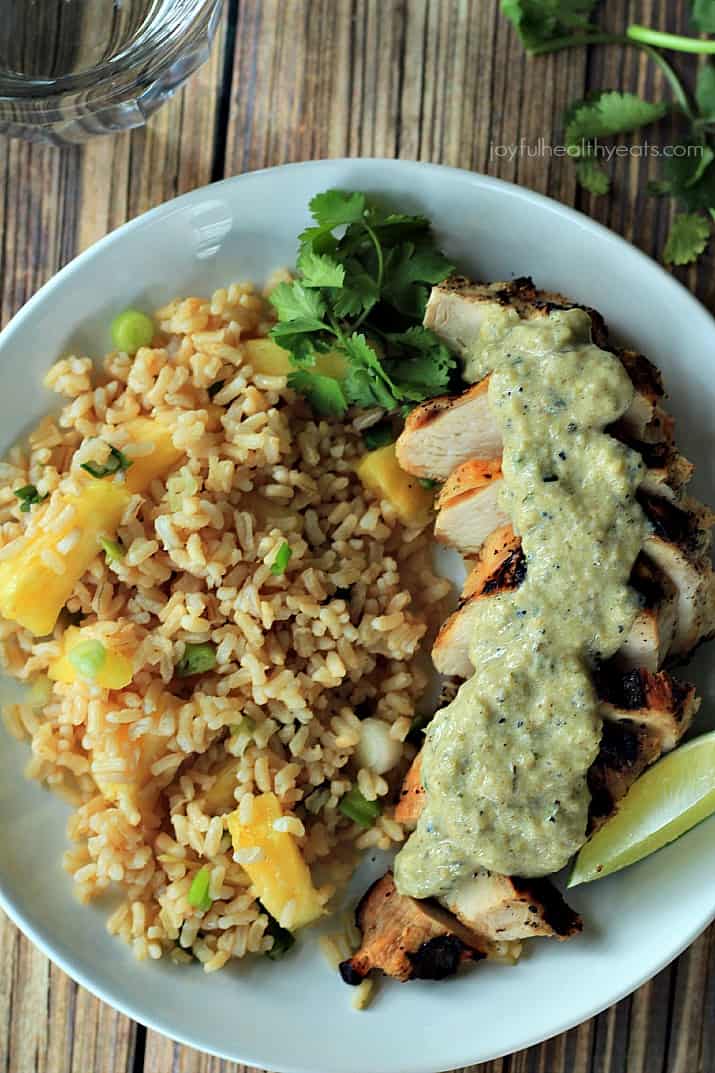 30 minute recipe that will fool anyone! Grilled Chicken Breast with Tomatillo Roasted Poblano Cream Sauce made with fresh ingredients and greek yogurt | m.albarakaa.com #glutenfree 俯视图的烤鸡与番茄烤波布拉诺奶油酱和菠萝米饭在盘子里