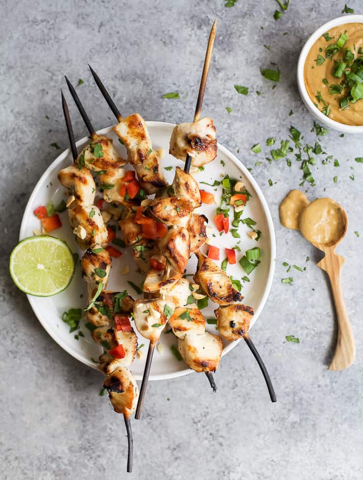 Grilled Sesame Lime Chicken with Spicy Thai Peanut Sauce 烤芝麻酸橙鸡配泰式花生酱在盘子里的图片