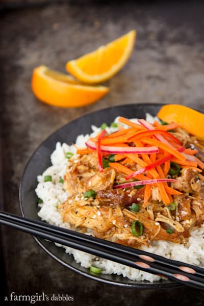 25 Healthy Crock Pot Recipes 一盘香橙鸡配新鲜的亚洲沙拉和一双筷子