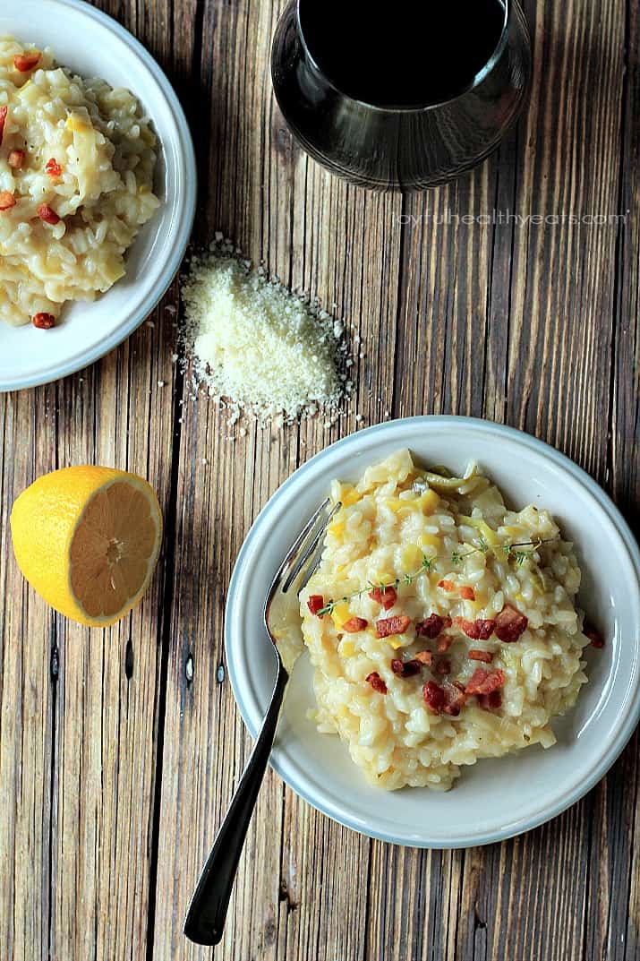 Creamy Leek Risotto with Crispy Pancetta, it's easier than you think. | m.albarakaa.com #comfortfood #recipes #italian #vegetables 顶视图奶油韭菜烩饭与脆意式烟肉在盘子上