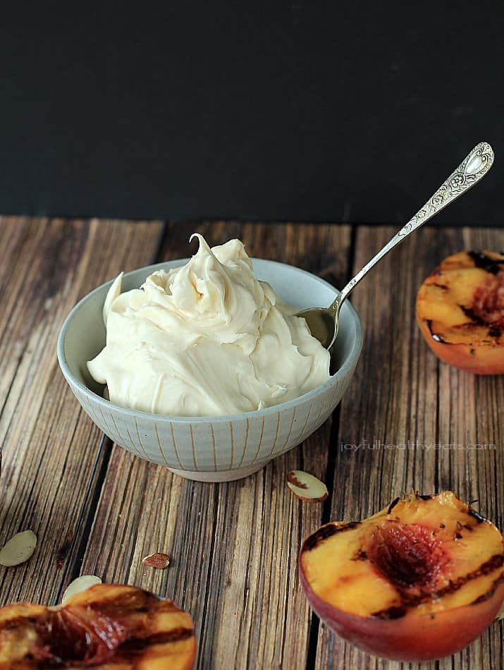 The perfect guilt free late night sweet fix... Grilled Peaches with Maple Honey Mascarpone Cheese | m.albarakaa.com 一碗枫蜜马斯卡彭奶酪,旁边是一块木板上的烤桃子
