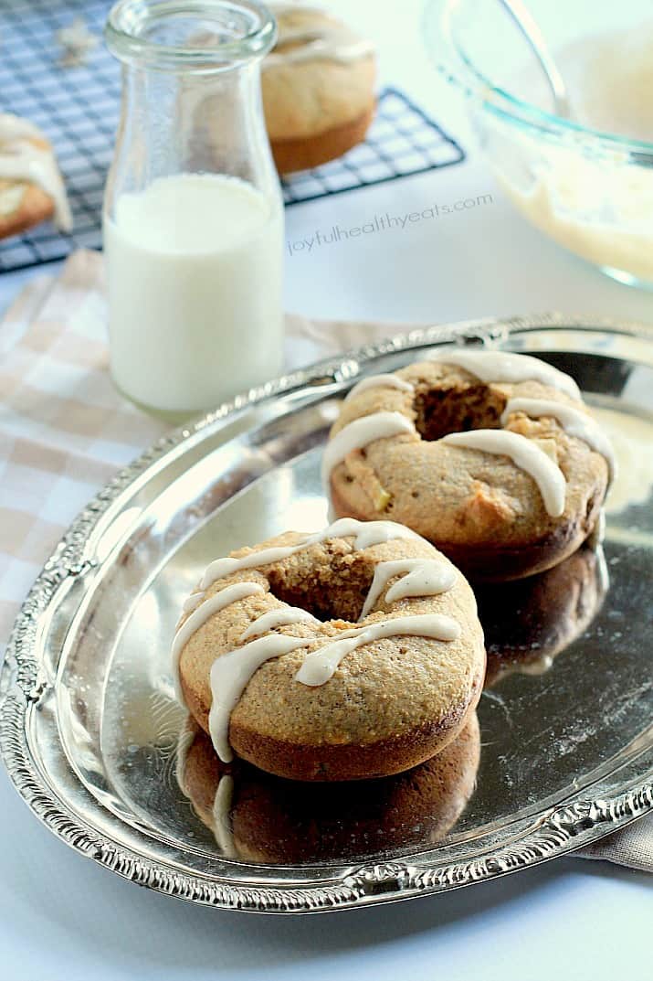 A healthier version of donuts for the fall! Baked Apple Donuts with a Cardamom Cream Cheese Glaze | m.albarakaa.com #fallrecipes #applerecipes 烤苹果甜甜圈与小豆蔻奶油奶酪釉在银盘