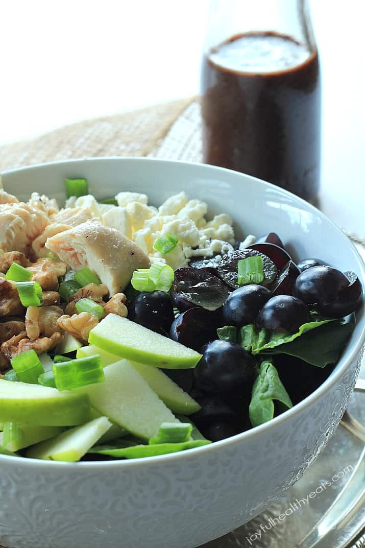 Chicken Feta Walnut Grape Chopped Salad with Balsamic Vinaigrette 鸡肉羊乳酪核桃葡萄碎沙拉在碗里,旁边是一瓶香醋