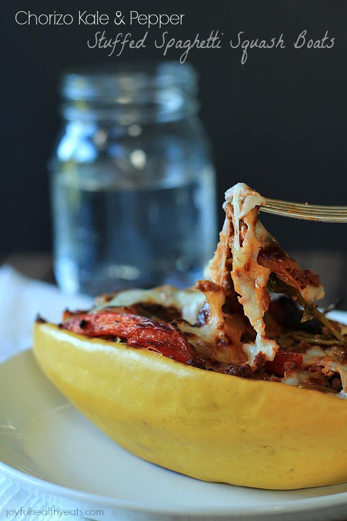 An easy healthy spanish inspired weeknight dinner, Chorizo Kale & Pepper Stuffed Spaghetti Squash Boats! | m.albarakaa.com 香肠甘蓝和胡椒填充意大利面南瓜船的特写,上面有融化的奶酪