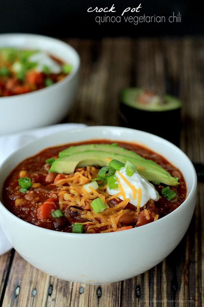 A hearty Quinoa Vegetarian Chili cooked to perfection in the Crock Pot, this soup recipe just screams fall comfort food! |m.albarakaa.com #freezerfriendly #easyrecipes 将藜麦素辣椒放入碗中,浇上奶酪丝、酸奶油、牛油果片和葱花