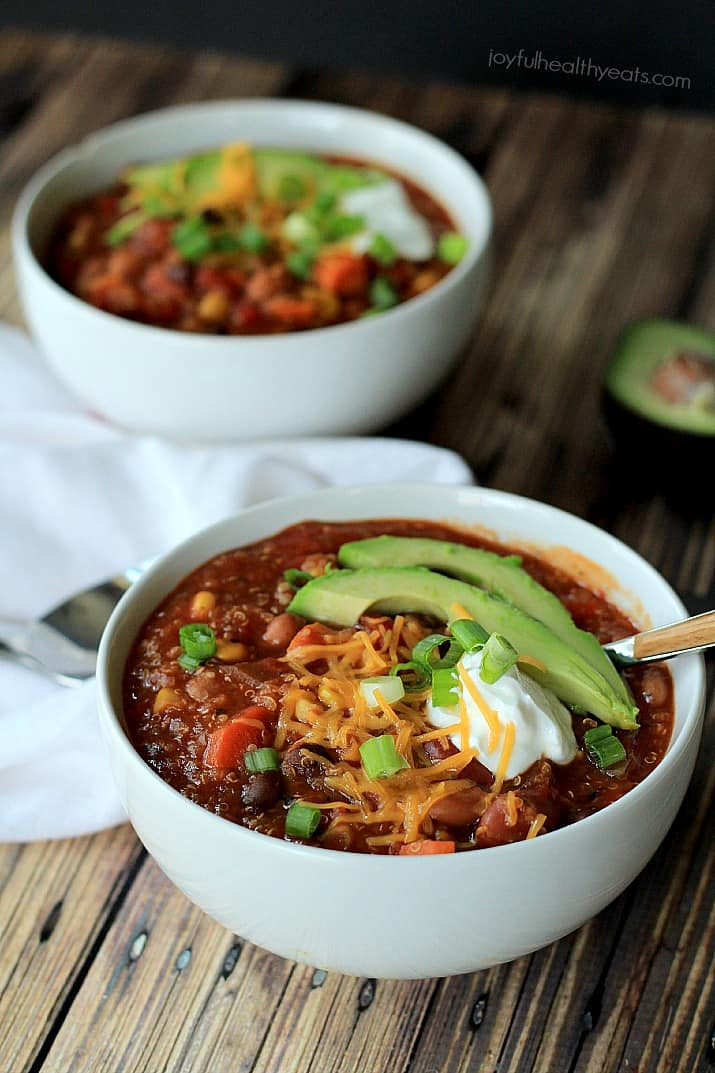 A hearty Quinoa Vegetarian Chili cooked to perfection in the Crock Pot, this soup recipe just screams fall comfort food! |m.albarakaa.com #freezerfriendly #easyrecipes 两碗藜麦素食辣椒,上面撒上葱花、奶酪丝、酸奶油和牛油果片