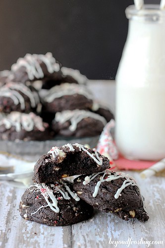 35 Must Have Christmas Cookie Recipes 三块双层巧克力拐杖糖饼干,旁边是一瓶牛奶和更多的饼干