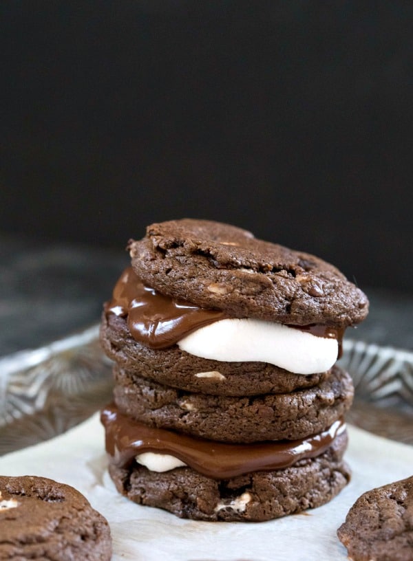 35 Must Have Christmas Cookie Recipes 两个热巧克力三明治饼干堆在羊皮纸上