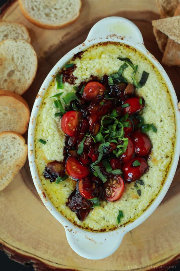 A quick appetizer recipe perfect for the holidays, this Baked Goat Cheese Dip will rock your world! | m.albarakaa.com 俯视图的烤山羊奶酪蘸上面有香熏烤面包和周围的crostini