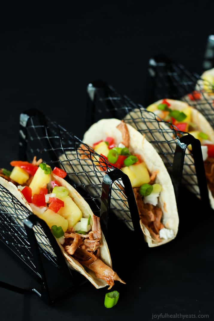 An easy Crock Pot Recipe your family will love! Hawaiian Pork Tacos filled with sweet pulled pork, fresh pineapple, red peppers, and goat cheese for a fun twist!! |joyfulhealthyeats.com #recipes Hawaiian Pork Tacos filled with sweet pulled pork, fresh pineapple, red peppers, and goat cheese in a taco holder rack