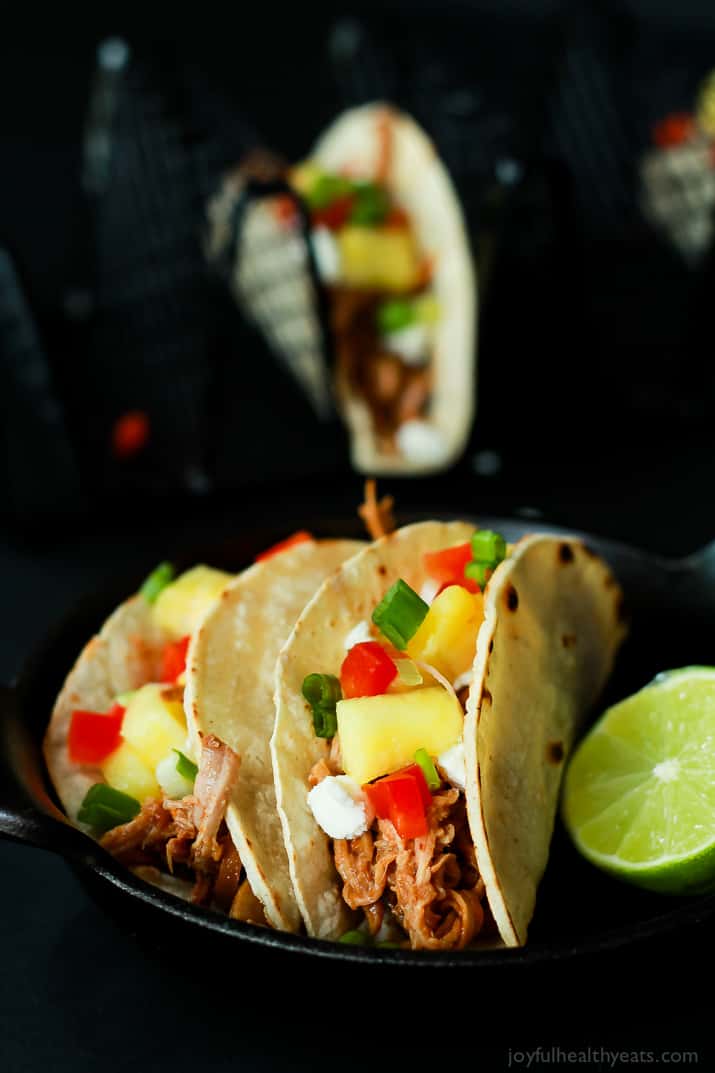 An easy Crock Pot Recipe your family will love! Hawaiian Pork Tacos filled with sweet pulled pork, fresh pineapple, red peppers, and goat cheese for a fun twist!! |joyfulhealthyeats.com #recipes Two Hawaiian Pork Tacos filled with sweet pulled pork, fresh pineapple, red peppers, and goat cheese