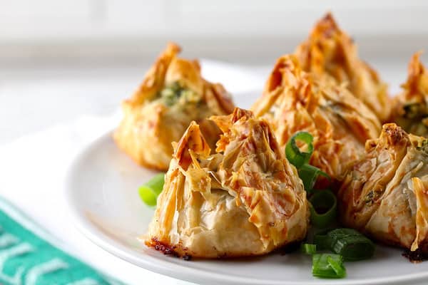 32 Easy Party Appetizers 白色盘子里的五个扇贝和香蒜酱钱包