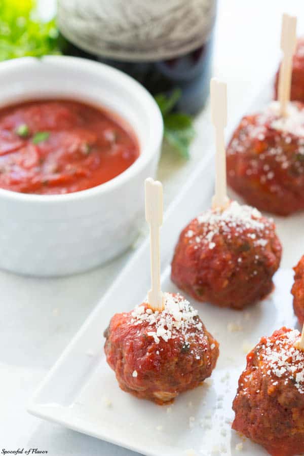32 Easy Party Appetizers 意大利马苏里拉馅肉丸旁边的容器番茄酱