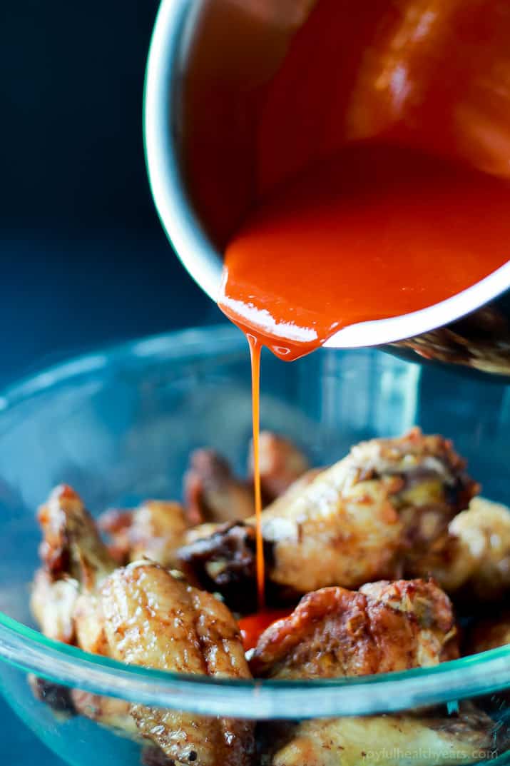A healthier version of the Classic Buffalo Baked Chicken Wings, these are baked and still have the same crispy sauce taste! | m.albarakaa.com #recipes #appetizer 水牛酱倒在一碗烤鸡翅上