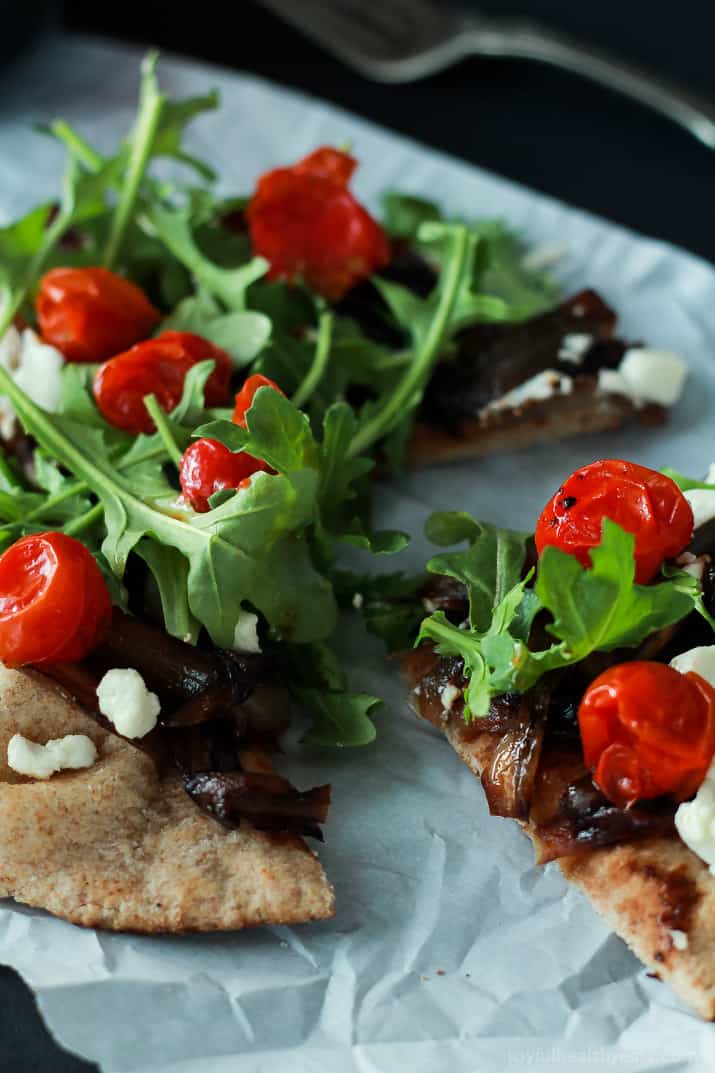 Add this low carb recipe to your collection of 30 minute meals; Pita Pizza that's not shy on flavor. | m.albarakaa.com #vegetarian #recipes 特写图像的皮塔比萨与香焦糖洋葱,芝麻菜,羊乳酪和番茄