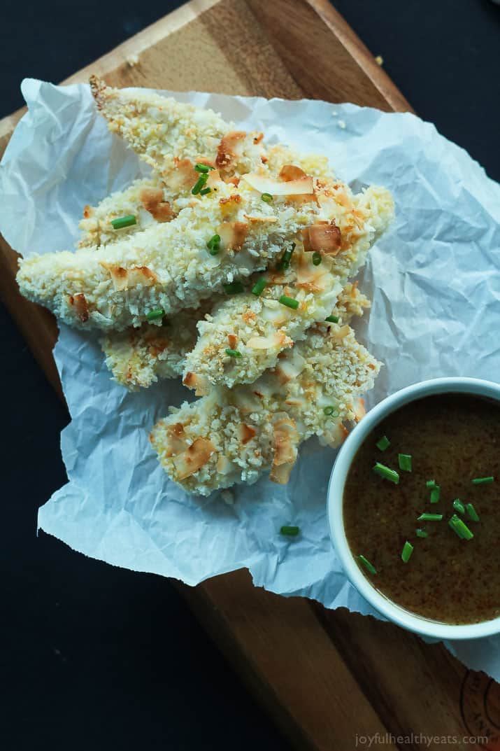 Dinner in 30 minutes! Baked Coconut Crusted Chicken Tenders using just 3 ingredients and served with a Tangy Honey Mustard Sauce for dunking. You will love this! | joyfulhealthyeats.com #recipe 俯瞰椰壳鸡柳配一杯蜂蜜芥末酱羊皮纸