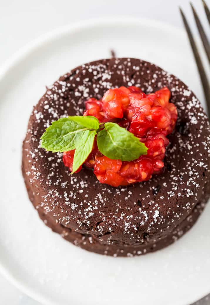 关闭Nutella巧克力熔岩蛋糕照片照片上面与香槟混乱的覆盆子