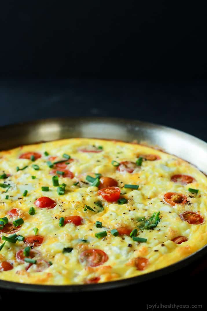 A Cheesy Bacon Spinach Frittata done in 30 minutes! This Spinach Frittata is packed with goat cheese, roasted red peppers, and bacon! Perfect for Brunch! | joyfulhealthyeats.com #easter #mothersday #recipes 有葡萄蕃茄的俗气培根菠菜frittata在煎锅