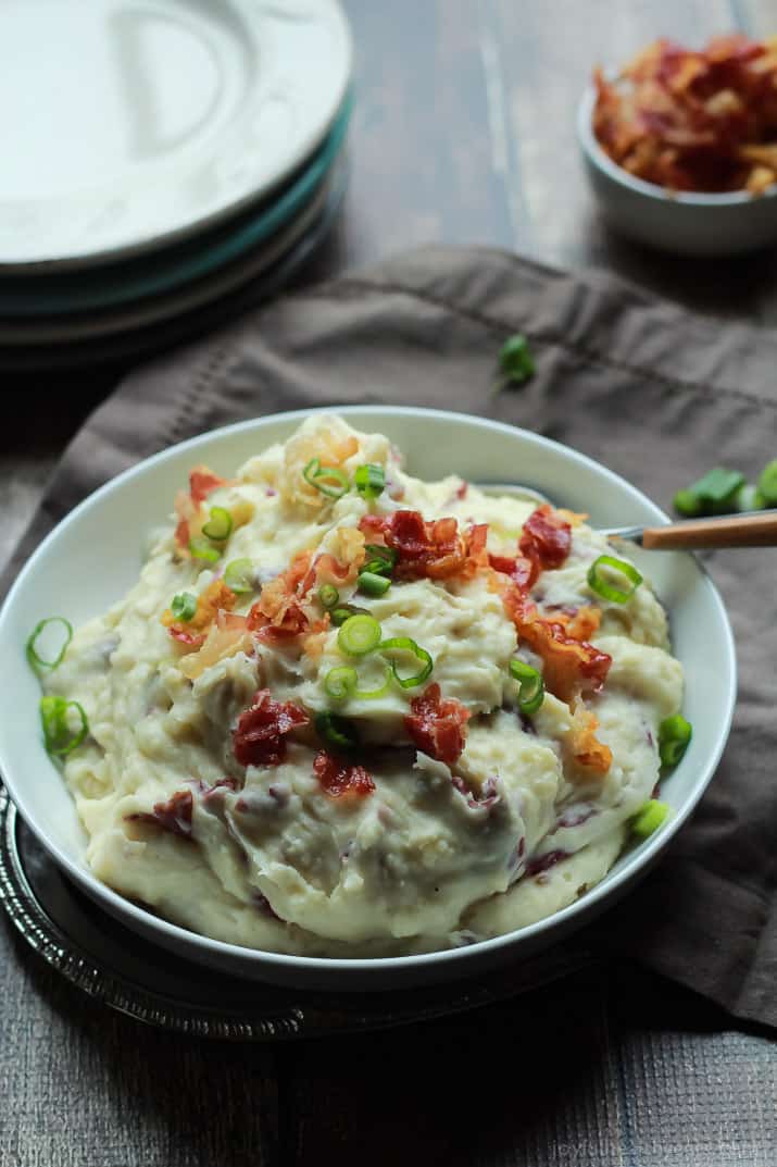 Creamy Goat Cheese Horseradish Mashed Potatoes 一个白色的碗,里面装着奶油山羊奶酪土豆泥和一个木柄勺子
