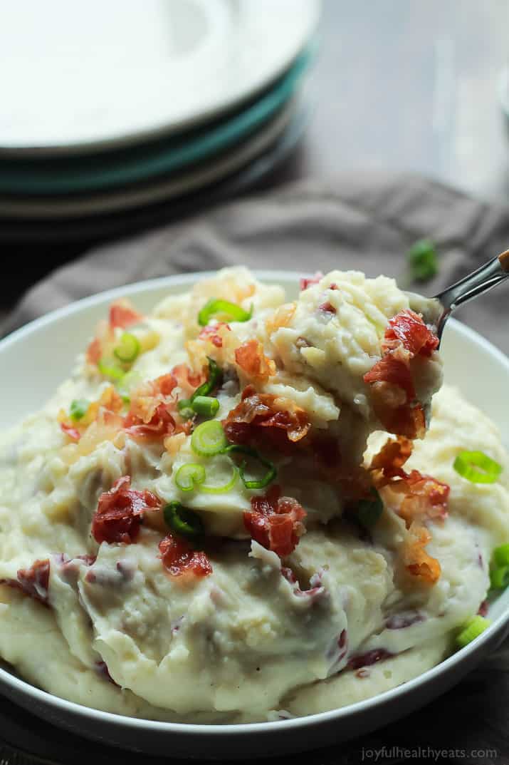 Creamy Goat Cheese Horseradish Mashed Potatoes 一碗奶油山羊奶酪辣根土豆泥,用金属勺子舀上一大口