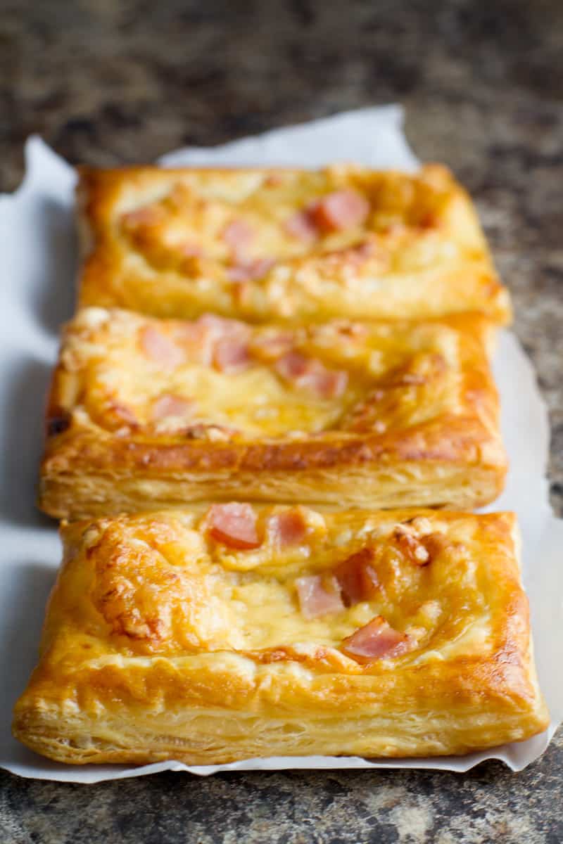 28 Last Minute Easter Brunch Ideas 在一张羊皮纸上放三个加拿大培根和奶酪美味馅饼