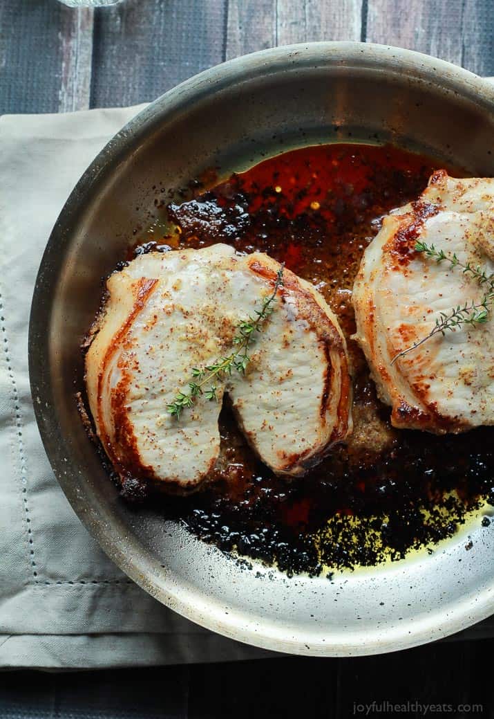 Mustard Crusted Pork Chops with Bourbon Glazed Apples 灼烧在金属煎锅的两种水多的猪肉chops