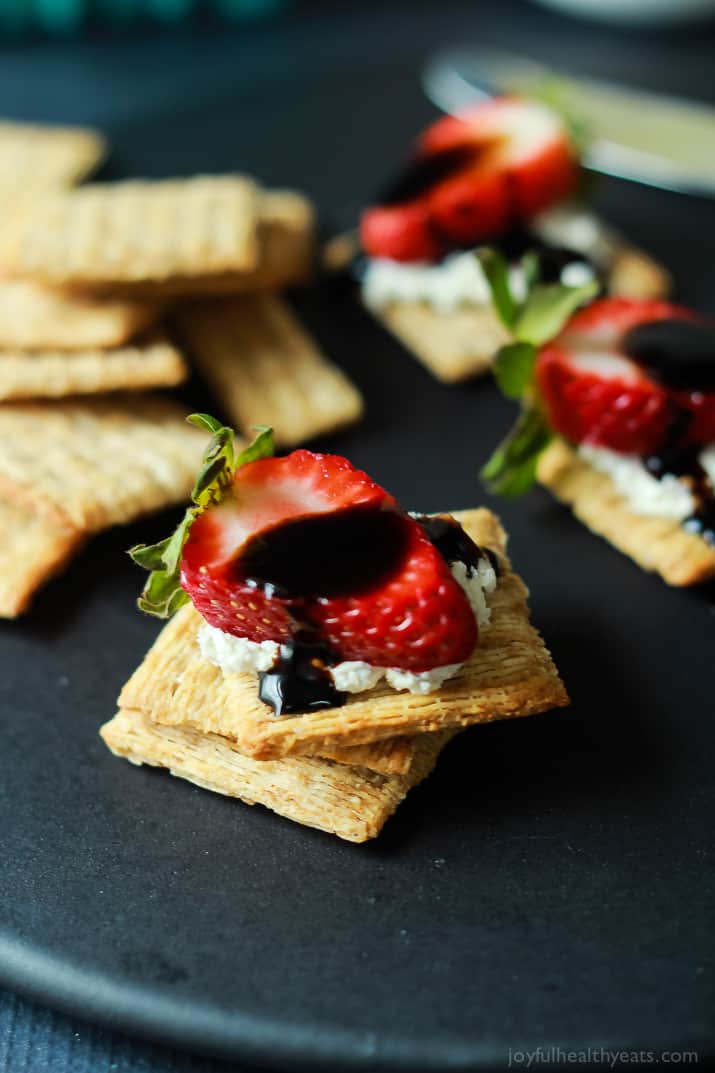 An easy spring party appetizer using less than 5 ingredients! Strawberry Goat Cheese Bites topped with a Balsamic Reduction Drizzle, takes only five minutes to make! | joyfulhealthyeats.com #recipes #appetizer #ad 草莓山羊奶酪夹在饼干上,上面淋上一层香醋