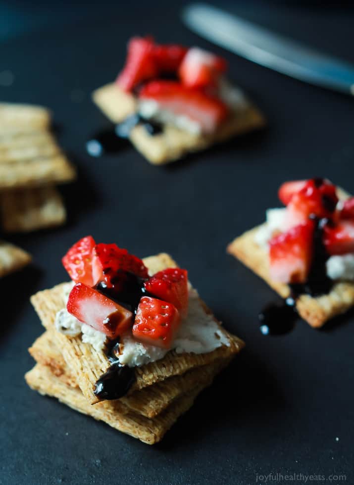 An easy spring party appetizer using less than 5 ingredients! Strawberry Goat Cheese Bites topped with a Balsamic Reduction Drizzle, takes only five minutes to make! | joyfulhealthyeats.com #recipes #appetizer #ad 草莓山羊奶酪夹在饼干上,上面淋上一层香醋