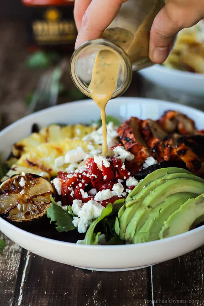 Harissa Lime Grilled Chicken Salad with a Creamy Cilantro Lime Vinaigrette, filled with grilled pineapple, limes, fresh avocado and an amazing dressing! Add to your list! | joyfulhealthyeats.com #glutenfree #recipes Creamy Cilantro Lime Vinaigrette being poured over Harissa Lime Grilled Chicken Salad