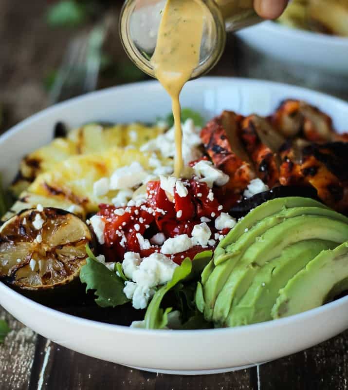 Harissa Lime Grilled Chicken Salad with a Creamy Cilantro Lime Vinaigrette, filled with grilled pineapple, limes, fresh avocado and an amazing dressing! Add to your list! | joyfulhealthyeats.com #glutenfree #recipes Creamy Cilantro Lime Vinaigrette being poured over Harissa Lime Grilled Chicken Salad
