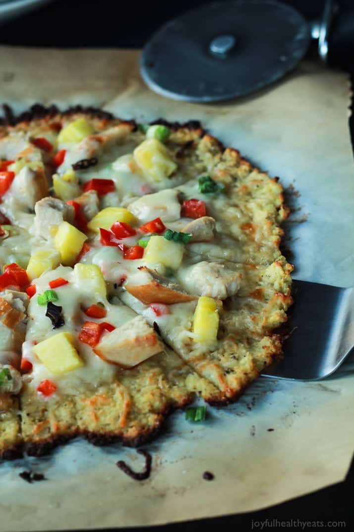 Thai Chili Chicken Pizza with a Cauliflower Crust, topped with a Sweet Spicy Thai Chili Sauce, fresh pineapple, bell peppers, and chicken. An easy gluten free pizza recipe that will be on your table in 25 minutes! | joyfulhealthyeats.com #recipes 泰式辣鸡肉披萨配花椰菜皮,淋上泰式甜辣酱、新鲜菠萝、灯笼椒和鸡肉。一个简单的无麸披萨配方,将在25分钟内放在你的桌子上!| joyfulhealthyeats.com食谱