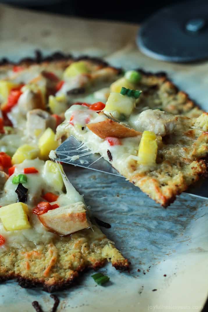 Thai Chili Chicken Pizza with a Cauliflower Crust, topped with a Sweet Spicy Thai Chili Sauce, fresh pineapple, bell peppers, and chicken. An easy gluten free pizza recipe that will be on your table in 25 minutes! | joyfulhealthyeats.com #recipes 泰式辣鸡肉披萨配花椰菜皮,淋上泰式甜辣酱、新鲜菠萝、灯笼椒和鸡肉。一个简单的无麸披萨配方,将在25分钟内放在你的桌子上!| joyfulhealthyeats.com食谱