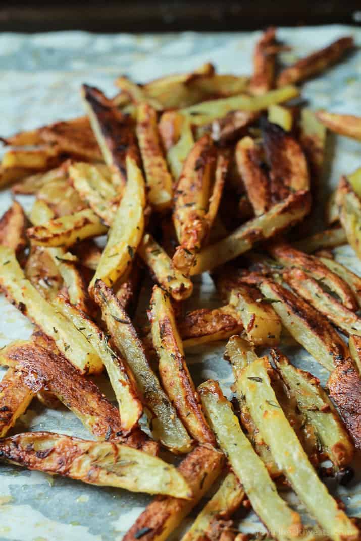 Crispy Baked Garlic Parmesan Fries are crispy on the outside and soft on the inside, the easiest skinny Baked Fries you will ever make! Only 6 ingredients but pack a phenomenal fresh herb taste! | joyfulhealthyeats.com #recipes #glutenfree 在羊皮纸的酥脆被烘烤的大蒜炸薯条炸薯条