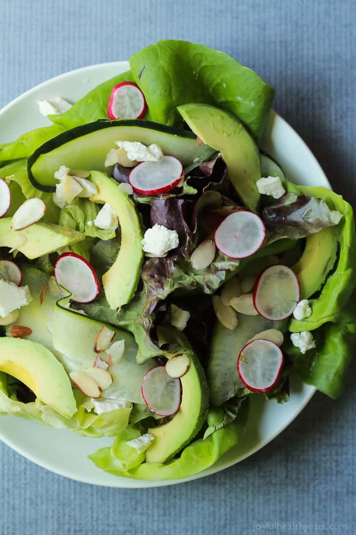A simple fresh Summer salad that takes 5 minutes - Avocado Butter Lettuce Salad filled with spicy radishes, almond slices, goat cheese, and topped with a Lemon Vinaigrette. | joyfulhealthyeats.com #recipe #glutenfree #vegetarian 鲕梨黄油莴苣沙拉顶视图
